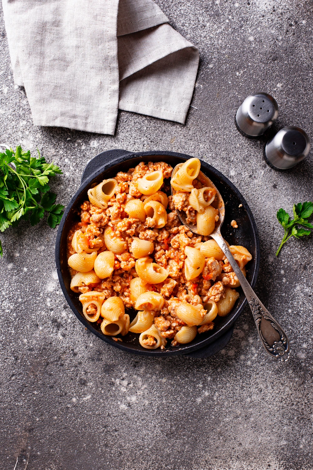 A vibrant bowl of lumache pasta with a savory tomato sauce and fresh basil garnish.