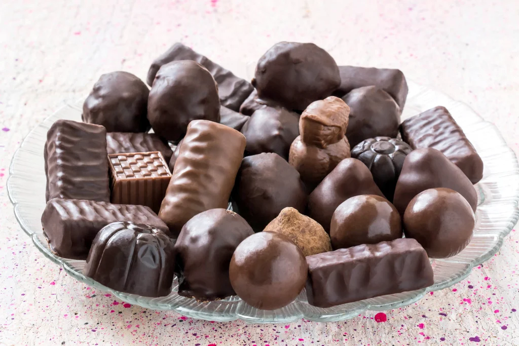 Creative chocolate candy variations with chili, dried fruits, and nuts in a modern kitchen.